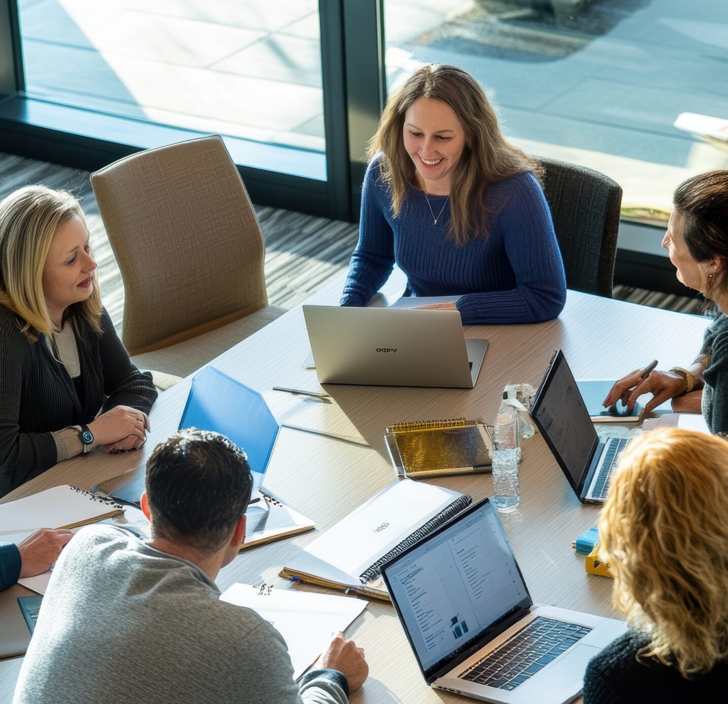 Business people having meeting around table using laptops